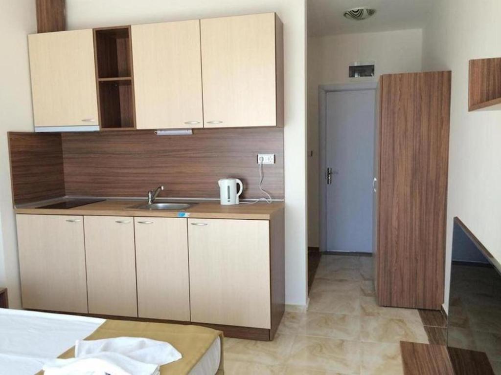 a kitchen with white cabinets and a sink in a room at Flower Street provides accommodations with free Wifi, air conditioning in Sunny Beach