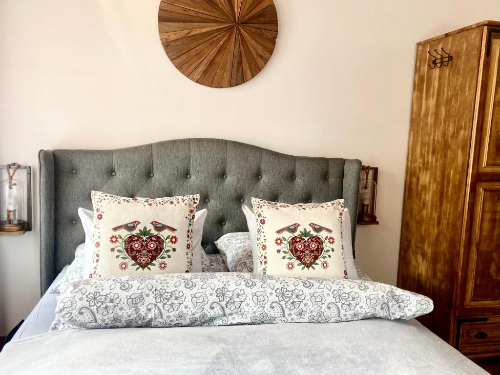1 dormitorio con cama con almohadas y reloj en la pared en Marina Zakopane, en Zakopane