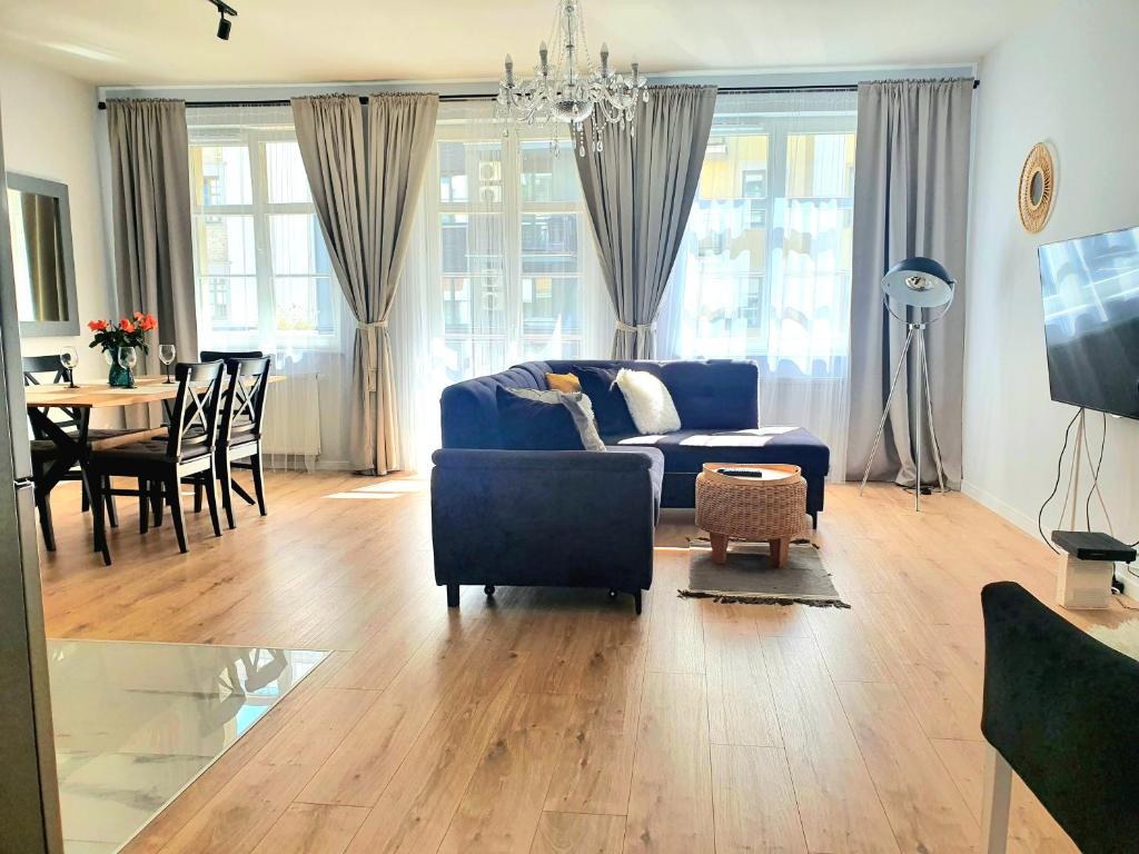 een woonkamer met een blauwe bank en een tafel bij Apartament Amber Dwie Sypialnie Stare Miasto in Elblag