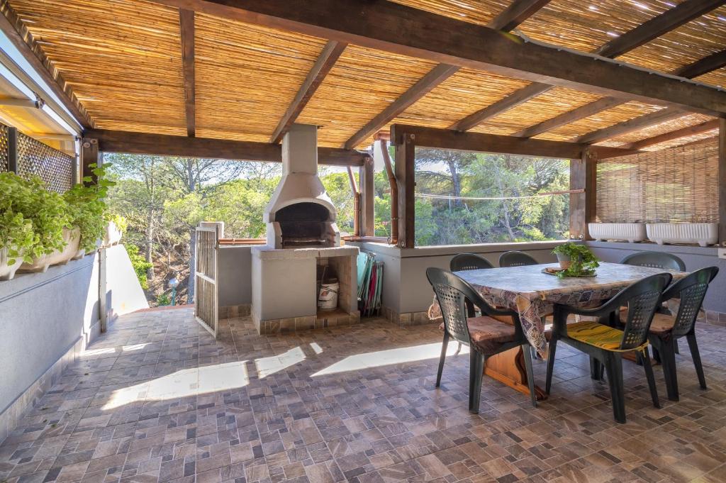 patio con mesa, sillas y fogones en Casa a 2 passi dalla Spiaggia, en Platamona