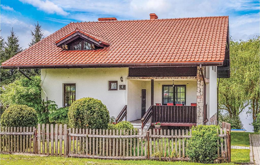 ein kleines weißes Haus mit orangefarbenem Dach in der Unterkunft Pet Friendly Home In Lidzbark Warminski With Kitchen in Redy