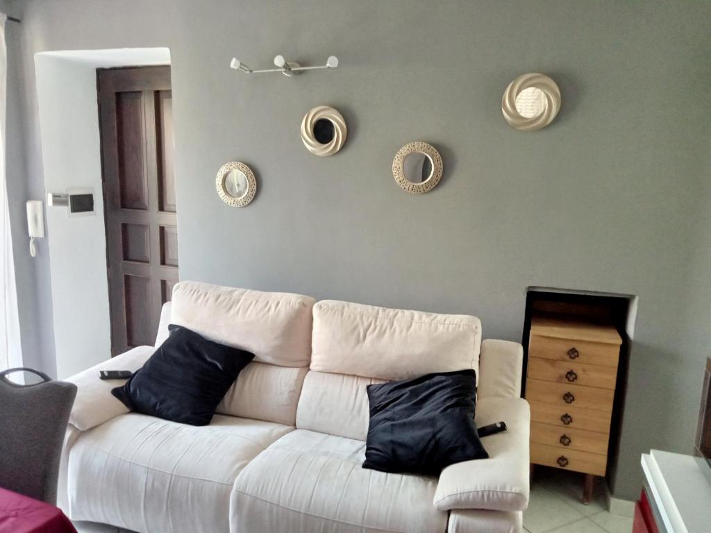 een woonkamer met een witte bank en borden aan de muur bij Ca Dei City in Coazze