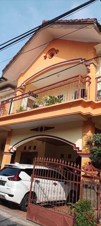 a white car parked in front of a house at Sierra Homestay Malang 3 BR AC in Ngadipuro