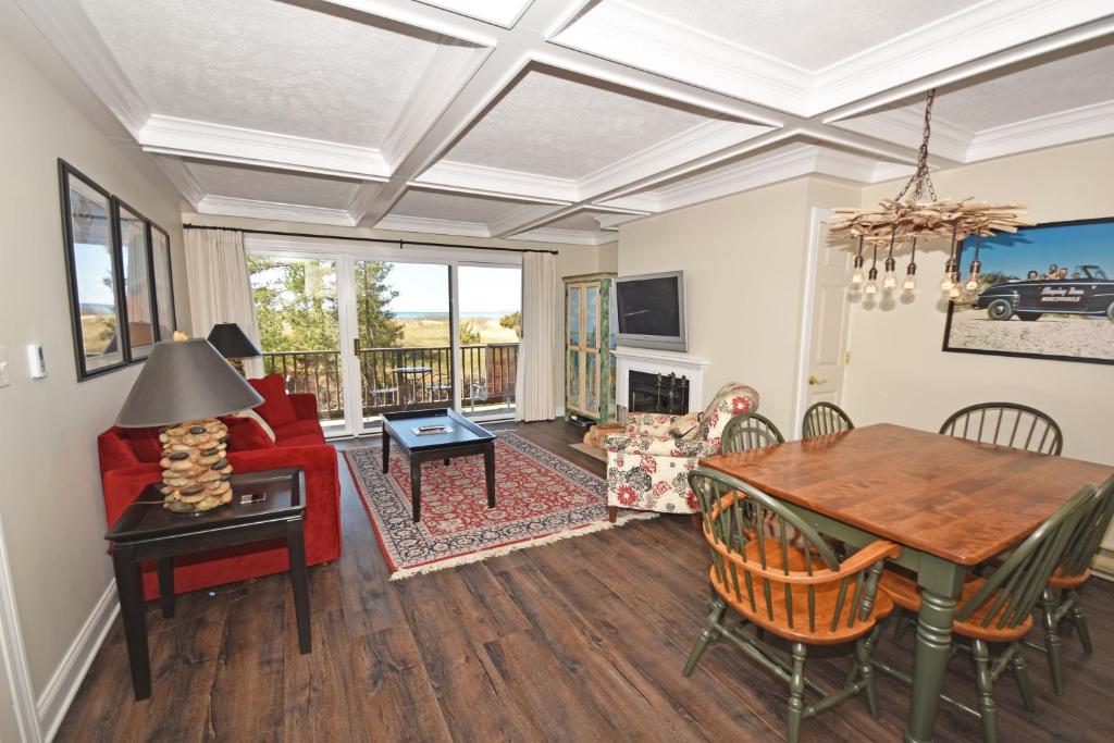 a living room with a red couch and a table at Gentle Winds 21 22 in Glen Arbor