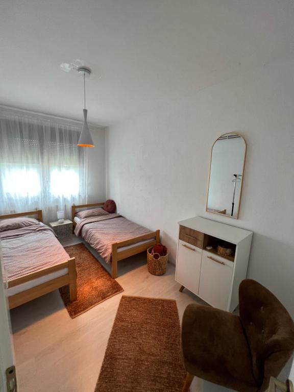 - un salon avec 2 lits et un miroir dans l'établissement Paradise, à Bihać