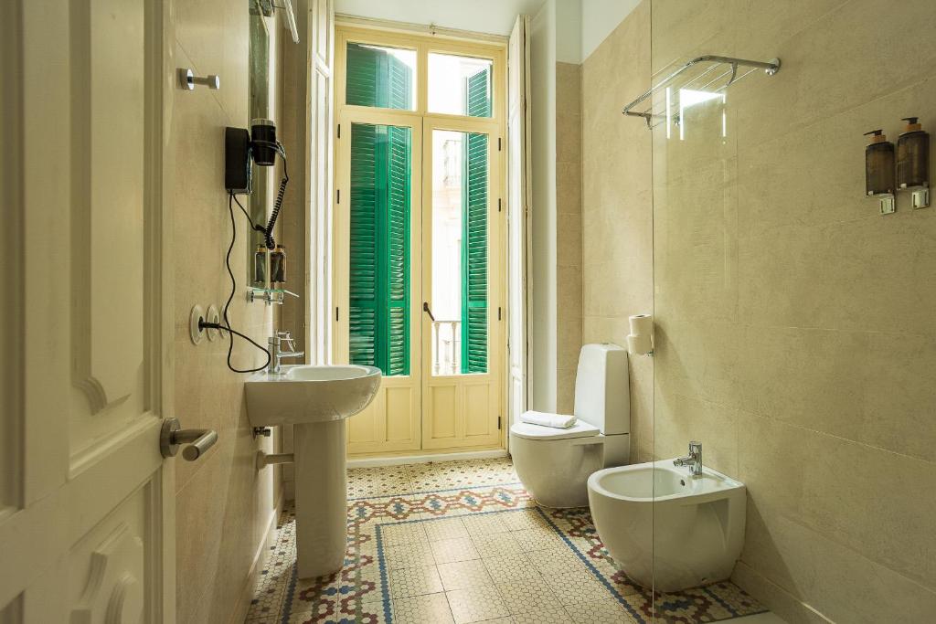 baño con lavabo y aseo y ventana en Madeinterranea Apartments, en Málaga