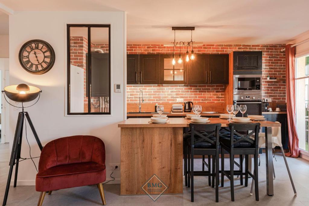 une cuisine avec une table et des chaises ainsi qu'un mur en briques dans l'établissement Résidence Val d'Europe Bmyguest, à Chessy