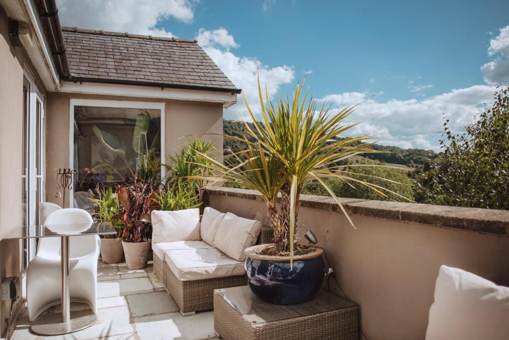 d'une terrasse avec un canapé et des plantes sur un balcon. dans l'établissement The Grange Matlock Bath, à Matlock