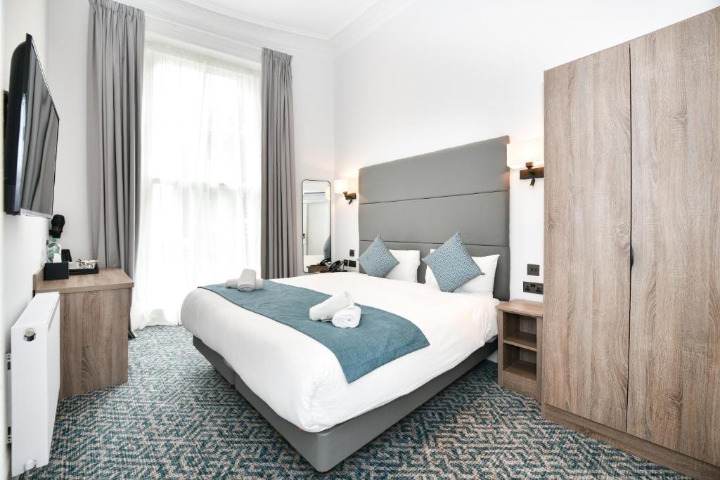 a hotel room with a large bed and a television at The J Hyde Park in London