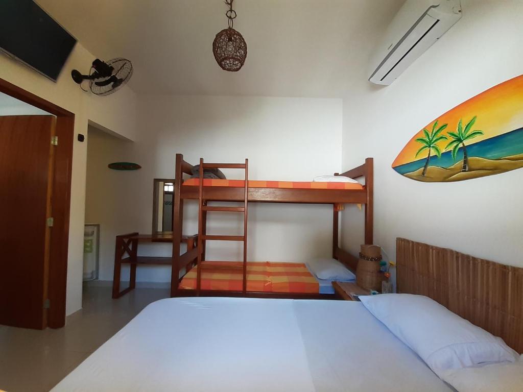 ein Schlafzimmer mit zwei Etagenbetten und einem Surfbrett an der Wand in der Unterkunft A Ver o Mar Beach House in Caraguatatuba