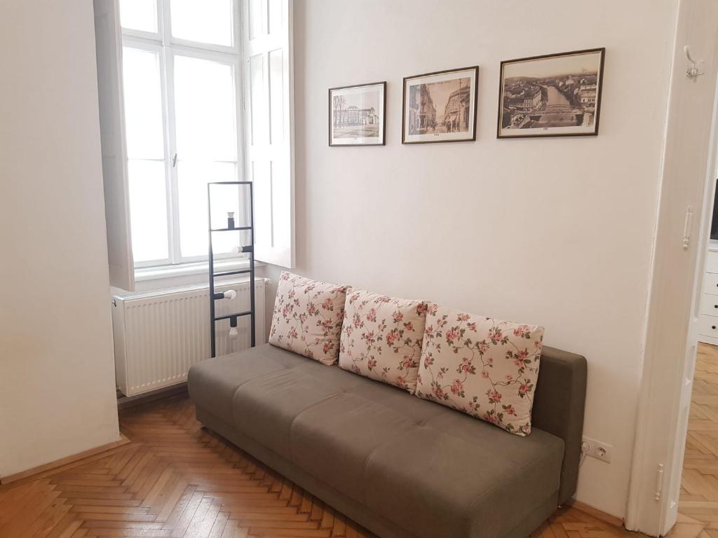 - un canapé avec deux oreillers dans le salon dans l'établissement Liberte Apartments, à Oradea