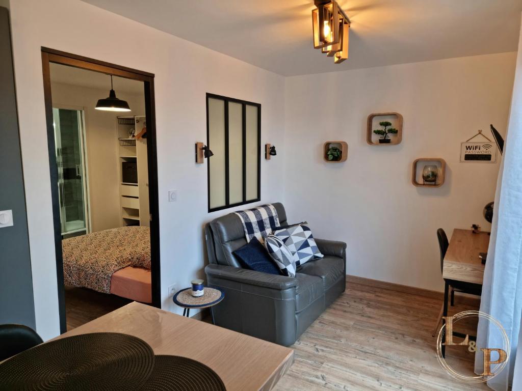 un soggiorno con sedia e letto di La Comoé - 5 min centre Pau - 1 chambre - Parking a Billère