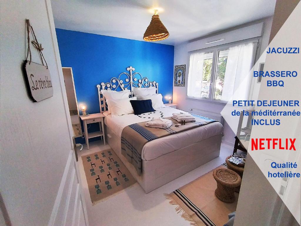 a bedroom with a bed with a blue wall at Dream of Mediterranean house, Jacuzzi, BBQ, Délices ensoleillés in Sartrouville