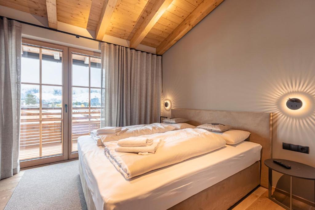 ein Schlafzimmer mit einem Bett und einem großen Fenster in der Unterkunft Chalet 149 Westendorf by ALPS RESORTS in Westendorf