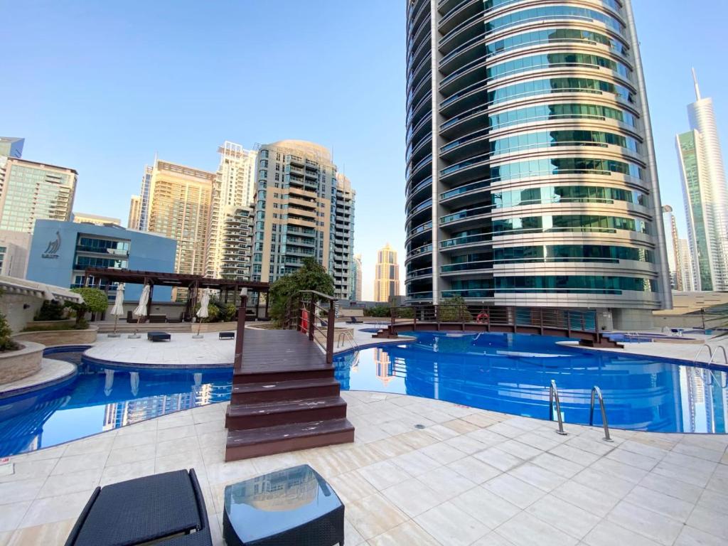 Dubai Marina - 5 bedroom, resort feel, great Amenities في دبي: مسبح في مدينة ذات مباني طويلة
