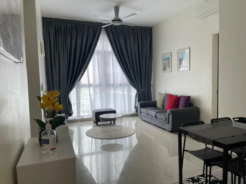 sala de estar con sofá y mesa en IOI Conezion Iman's Home with Pool View Unit en Putrajaya