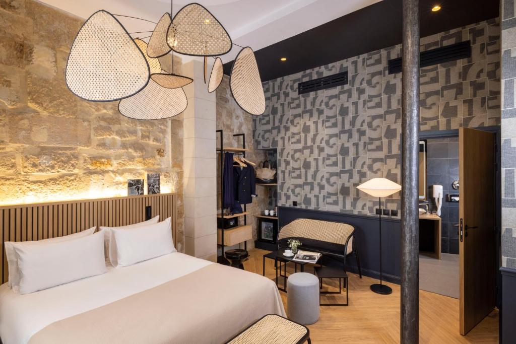 a bedroom with a bed and a desk and a chair at Hotel Abbatial Saint Germain in Paris