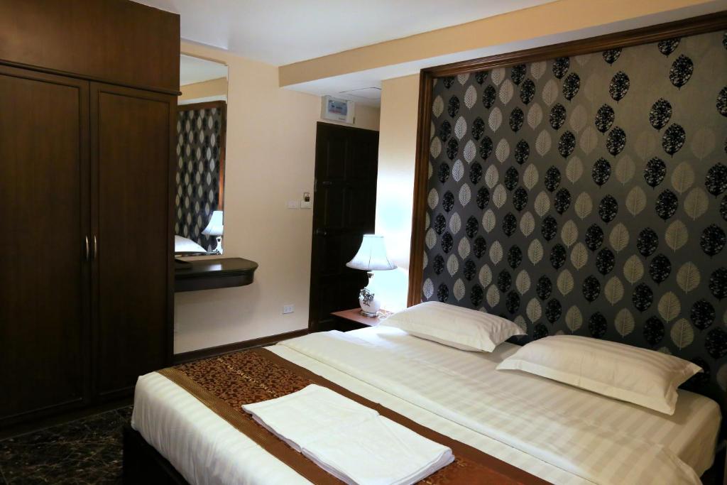 a hotel room with a bed with a headboard at Katesiree House in Pattaya Central
