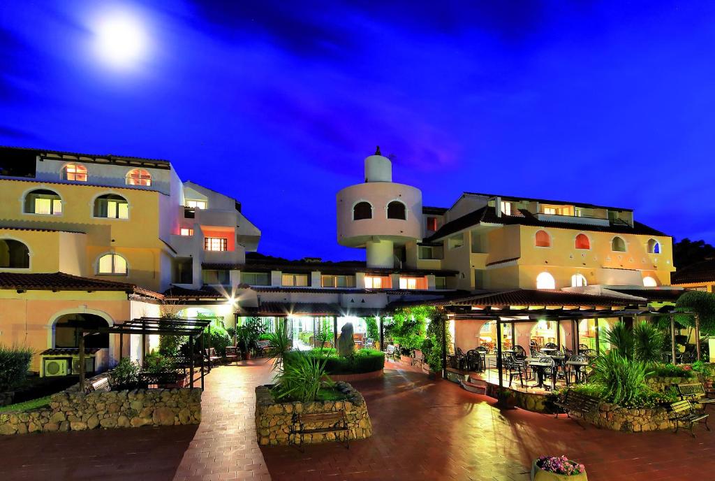 um grande edifício à noite com a lua no céu em Colonna Beach Hotel em Marinella