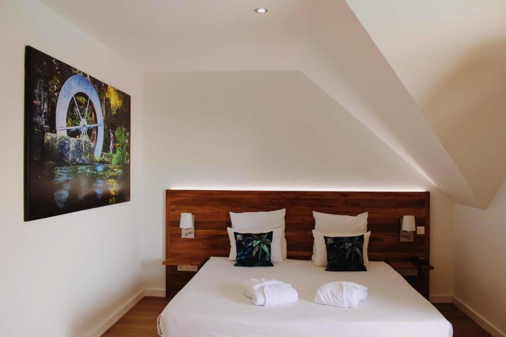 a bedroom with a large white bed with two pillows at Hôtel Exsel Créolia in Saint-Denis