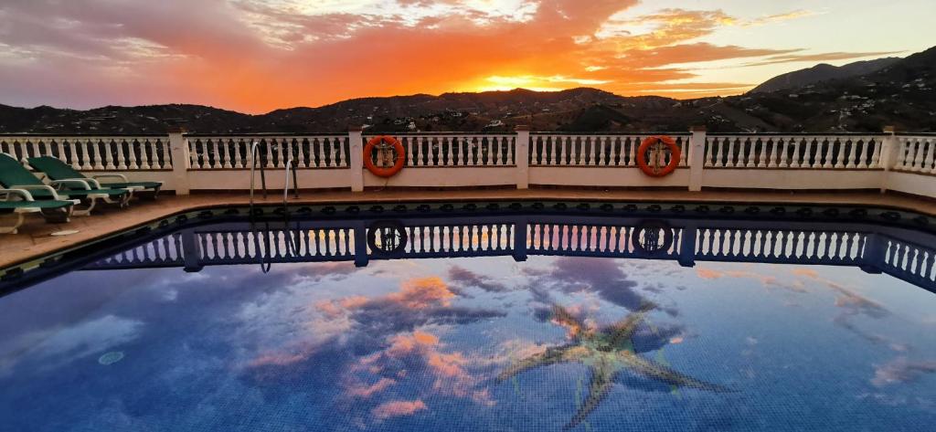 un reflejo de la puesta de sol en un charco de agua en Apartamentos Rosamarina, en Frigiliana