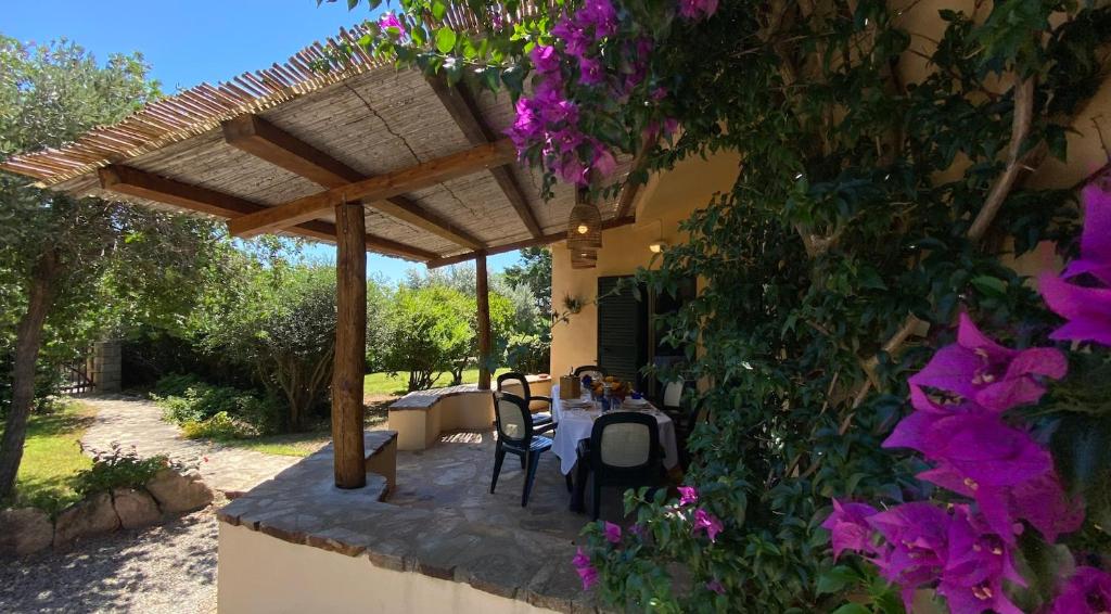 a patio with a table and chairs under a pergola at Villa la Bonaccia in La Maddalena