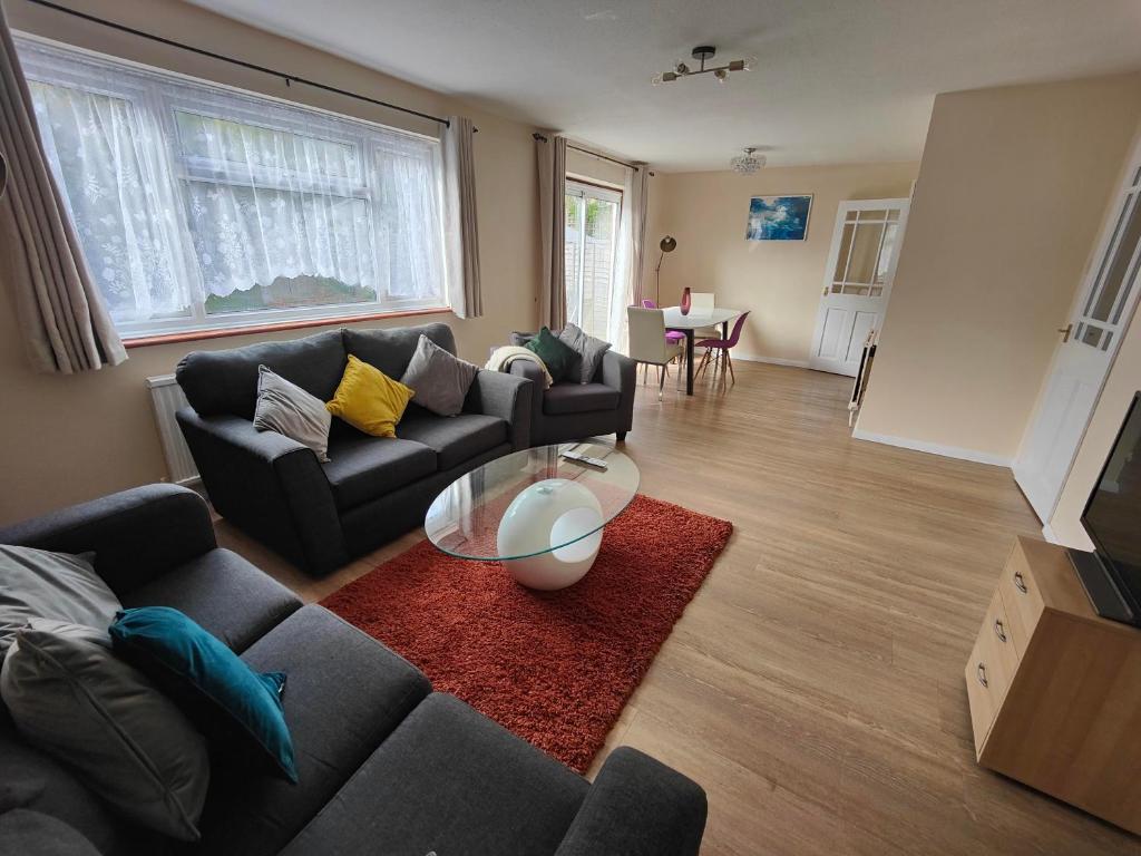 uma sala de estar com um sofá e uma mesa em Piping House 4bedroom em Otterbourne
