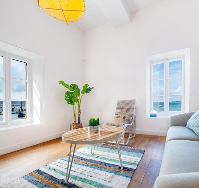 a living room with a table and a couch at L'appartementducroisic - Sur le port, vue mer in Le Croisic