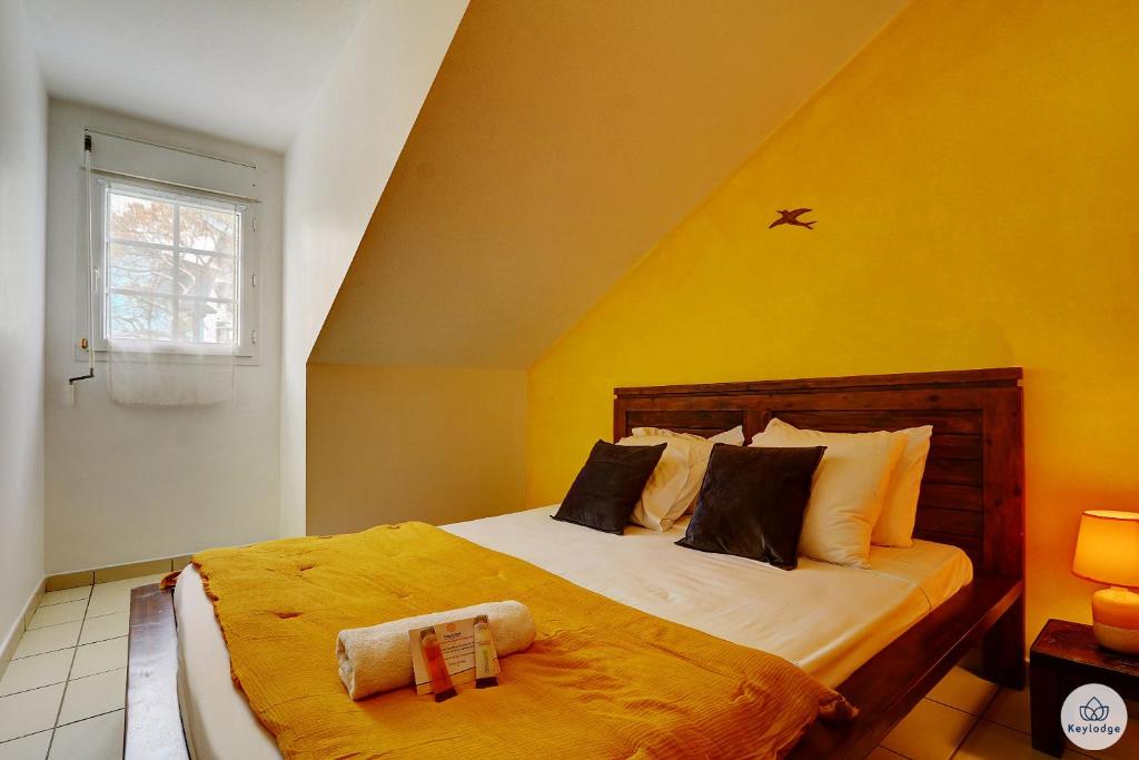 - une chambre avec un grand lit aux murs jaunes dans l'établissement T3 Rustica - Duplex à Saint-Denis, à Sainte-Clotilde