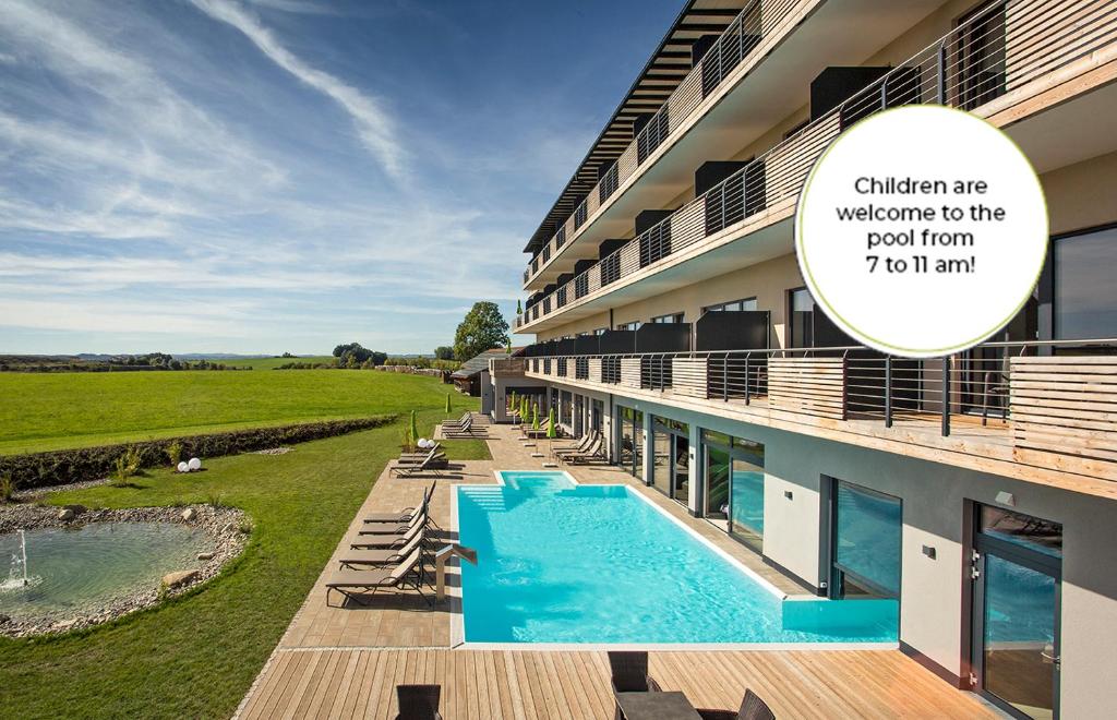 - une vue sur un bâtiment avec piscine dans l'établissement Das Weitblick Allgäu, à Marktoberdorf