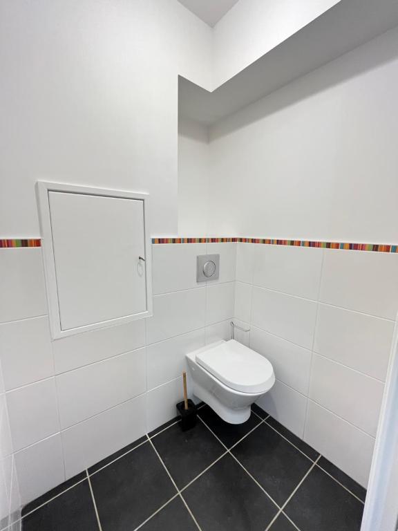 a white bathroom with a toilet and a mirror at PoNSARDIN - Bel appartement avec balcon et Parking in Reims
