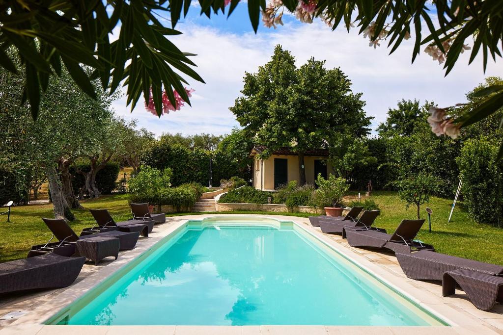 una piscina con sedie a sdraio e una piscina di Villa Roberta - Homelike Villas a Fano