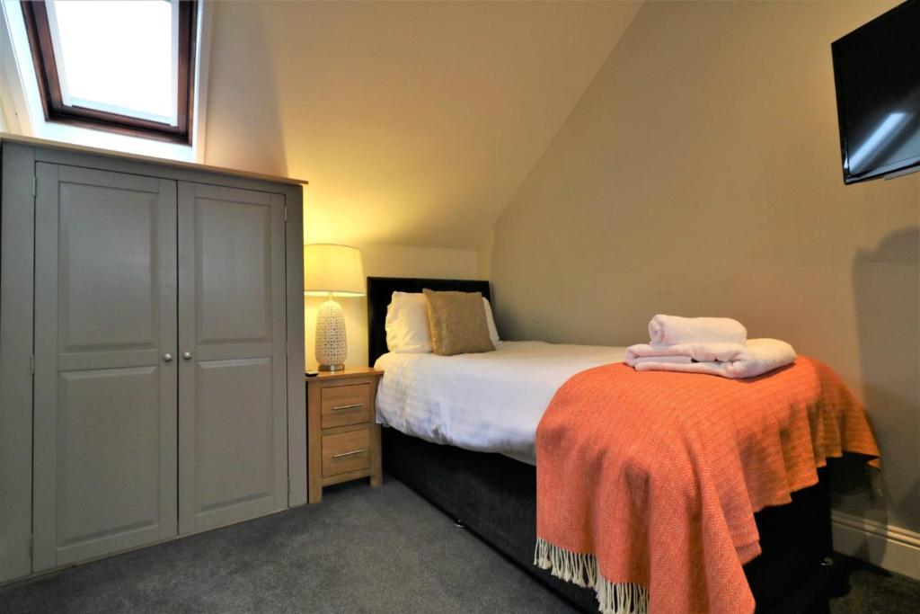 ein Schlafzimmer mit einem Bett und einer Kommode mit Handtüchern darauf in der Unterkunft Signature - Linden Cottage Room 4 in Airdrie