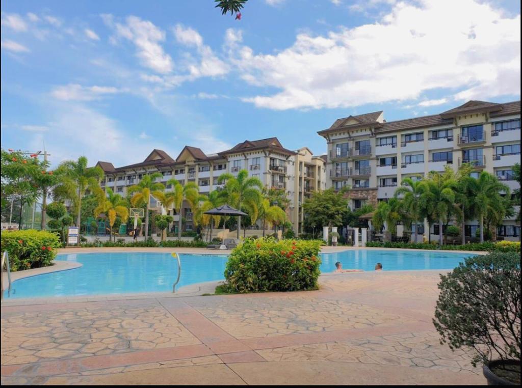 a resort swimming pool with palm trees and buildings at Condo for rent in Davao City in Davao City