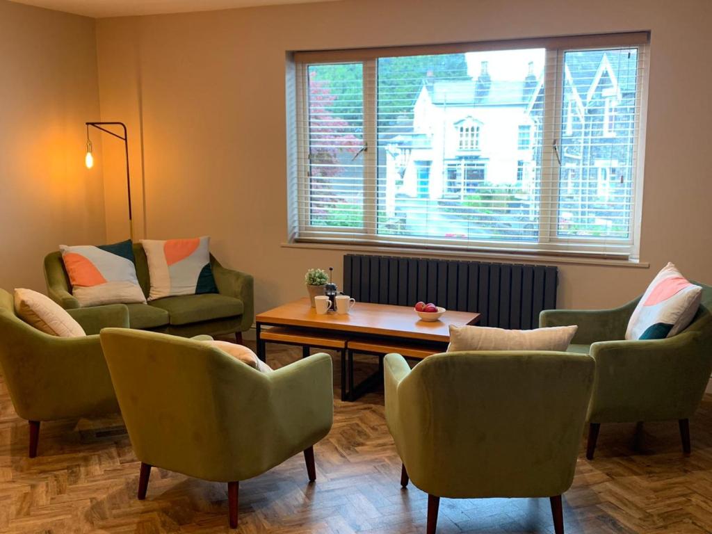 a living room with chairs and a table and a window at Apple Tree at Elim Mews in Bowness-on-Windermere