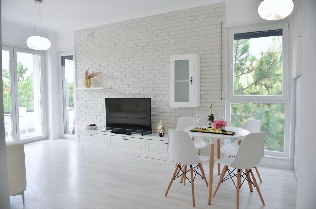 uma sala de estar branca com uma mesa e uma televisão em Valamar Apartament em Durrës