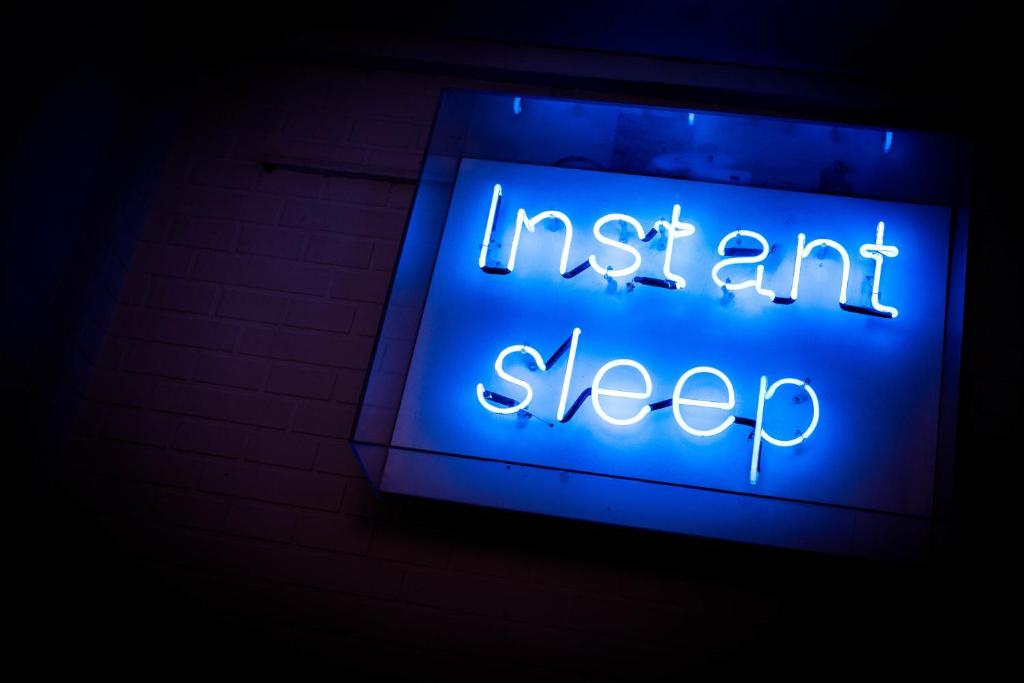 a blue neon sign with the words instant sleep at instantSleep Backpackerhostel St Pauli in Hamburg