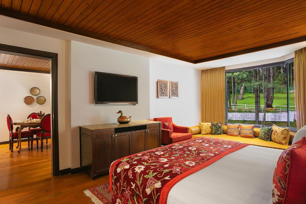 a bedroom with a bed and a tv and a couch at Welcomhotel by ITC Hotels, Pine N Peak, Pahalgam in Pahalgām