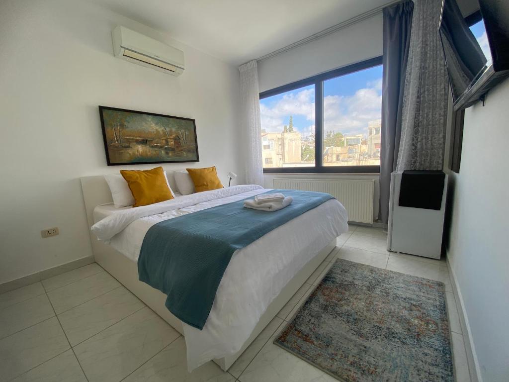 a bedroom with a large bed and a large window at Lemon Tree Residence in Amman