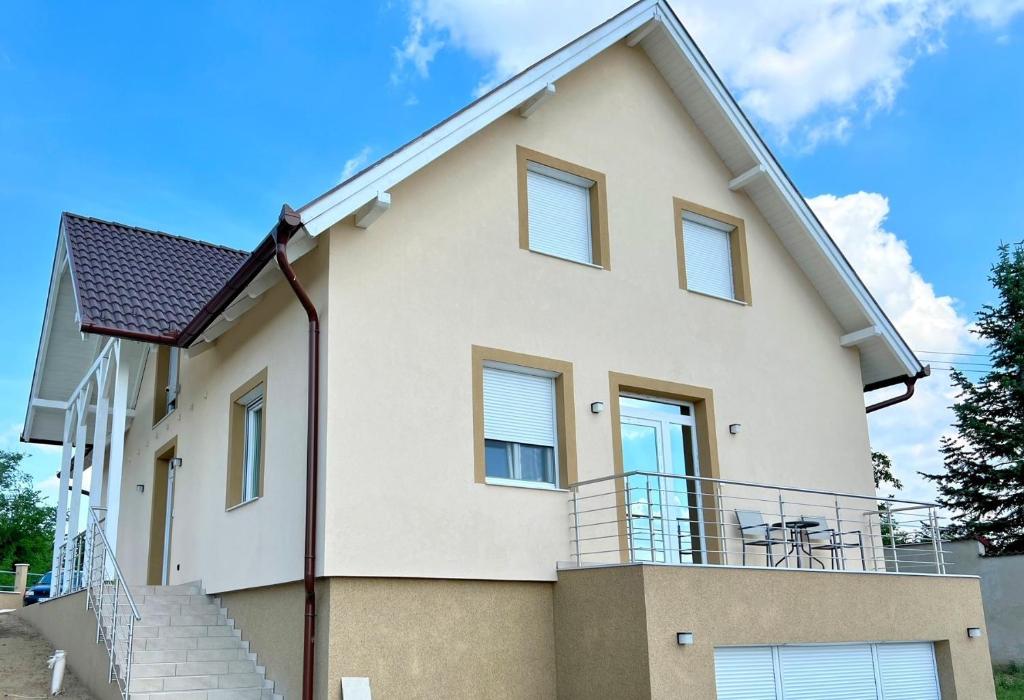 a large white house with a balcony at Panoráma Apartman Mogyoród in Mogyoród