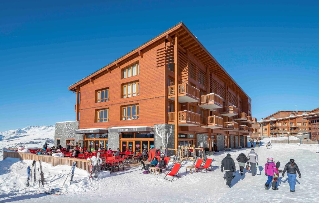 a ski lodge with people standing outside of it in the snow at travelski home premium - Résidence Edenarc 5 stars in Arc 1800