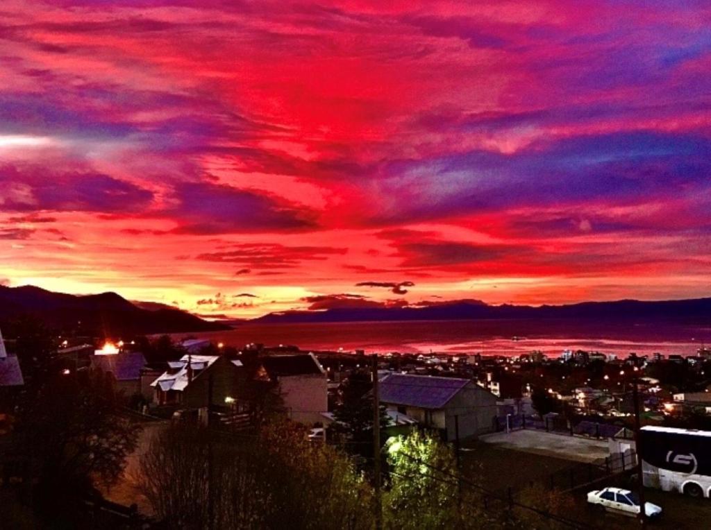 a sunset over a city with a red sky at Dolores House PREMIUM in Ushuaia