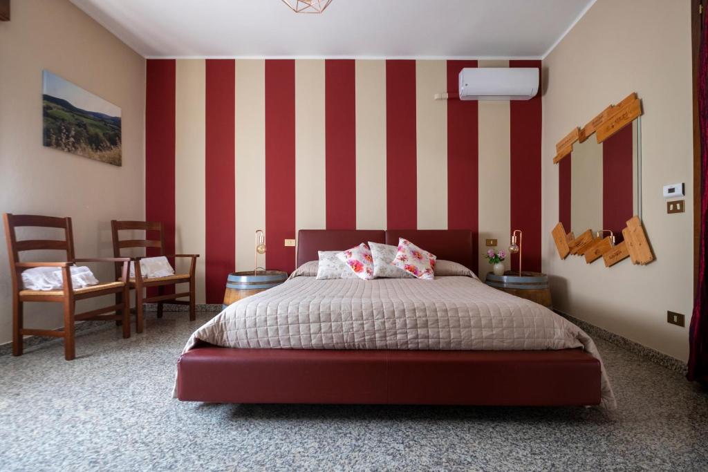 1 dormitorio con 1 cama con rayas rojas y blancas en Berici Bed and Breakfast, en Nanto