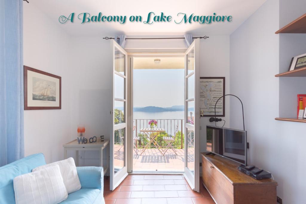 een woonkamer met een deur naar een balkon bij A Balcony on Lake Maggiore in Belgirate