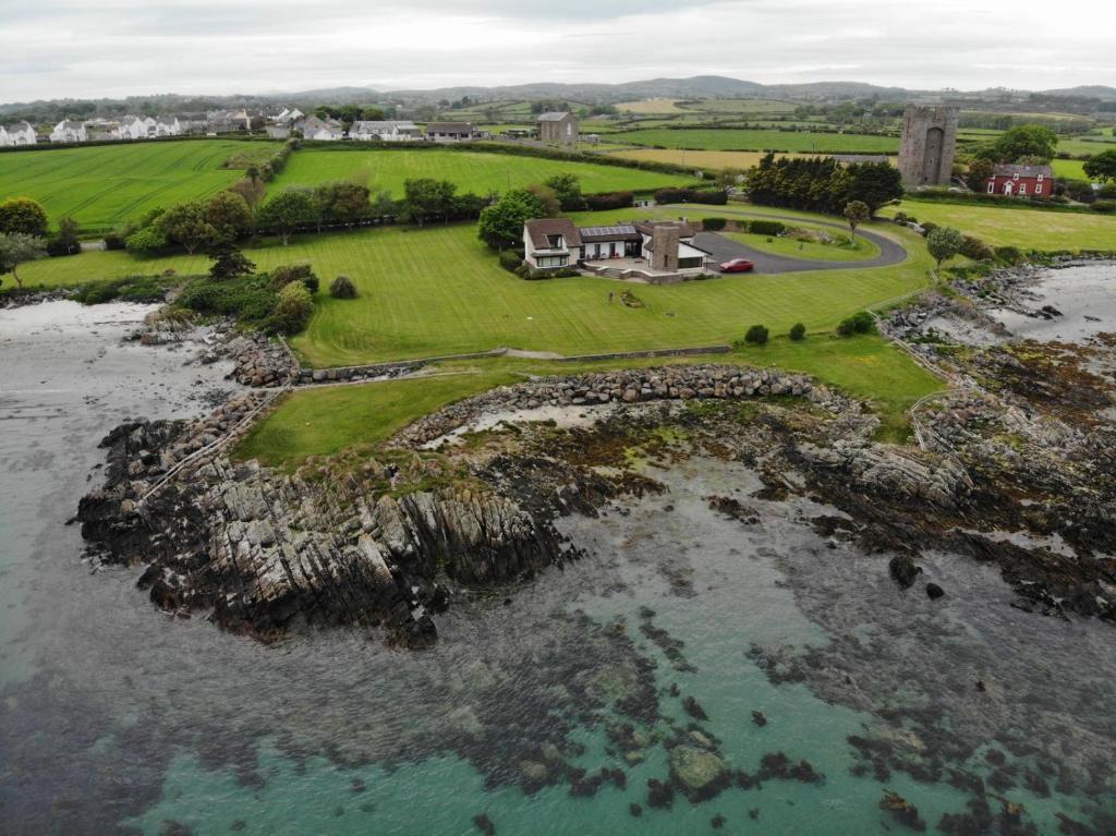an aerial view of a house on a island in the water at Castlepoint in Strangford