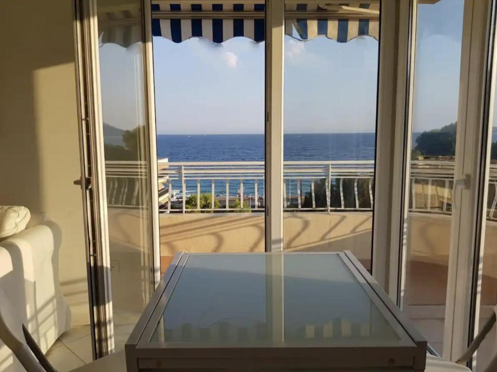 Cette chambre dispose d'une table en verre et offre une vue sur l'océan. dans l'établissement C060-Bel Appartement avec Vue Mer - Picaud, à Cannes