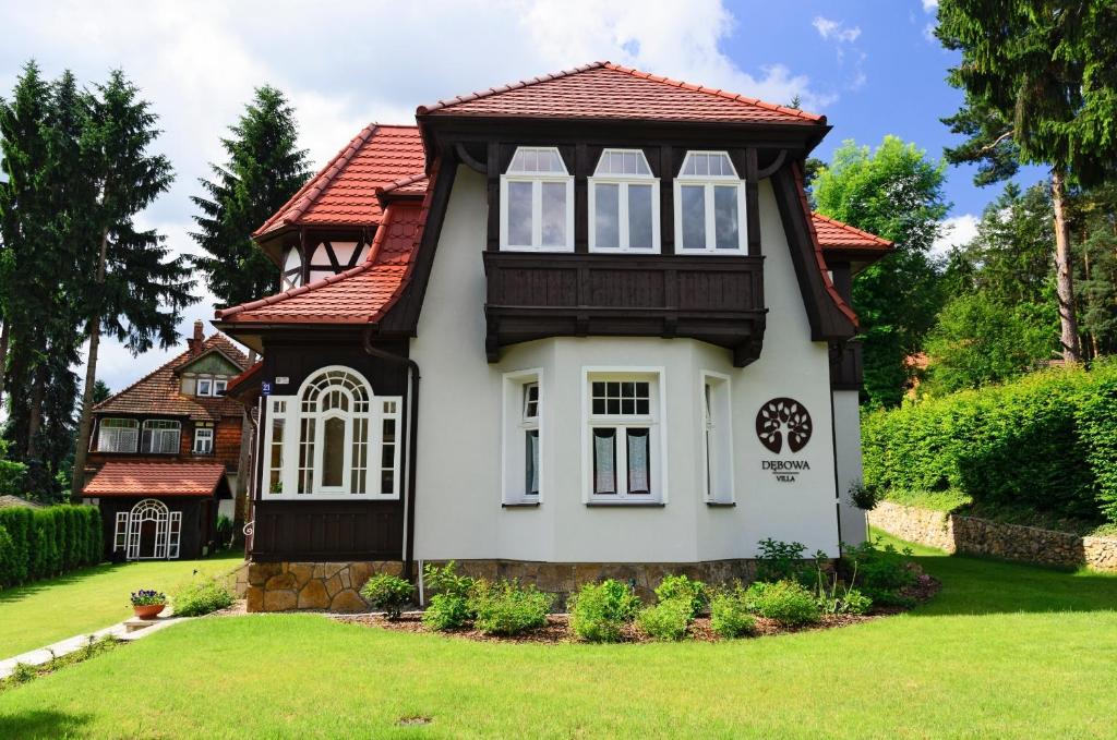 una pequeña casa con techo rojo en Villa Dębowa, en Polanica-Zdrój
