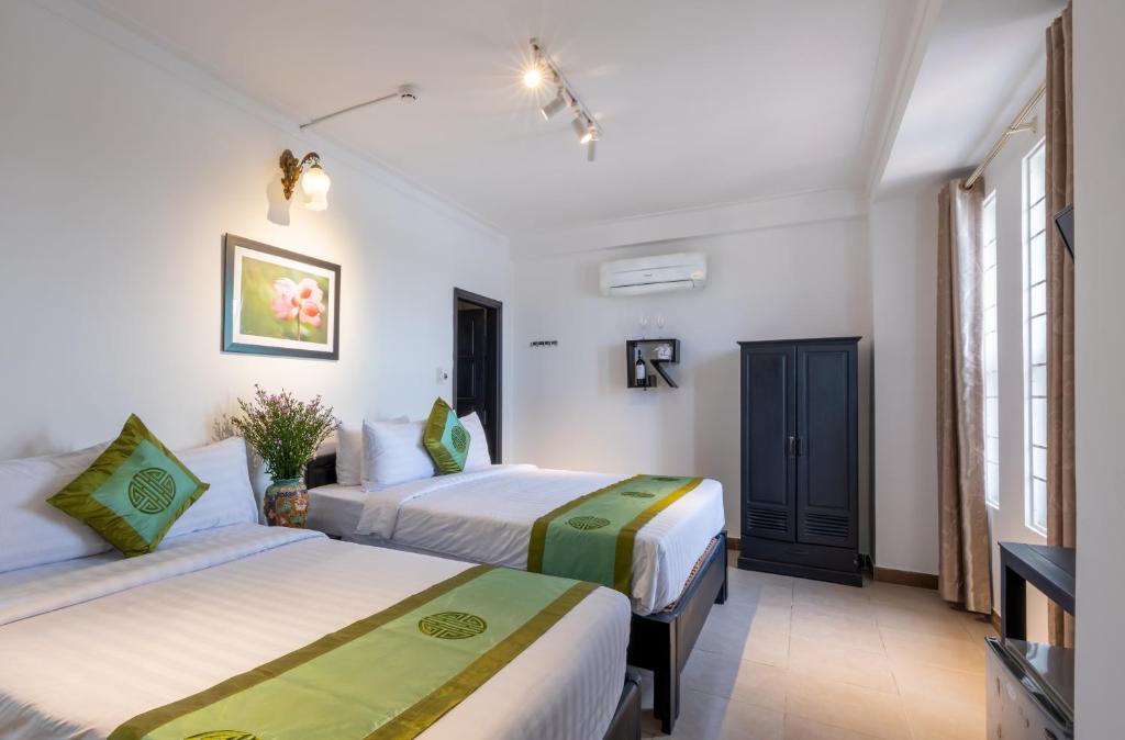 Giường trong phòng chung tại Charming Riverside Hotel
