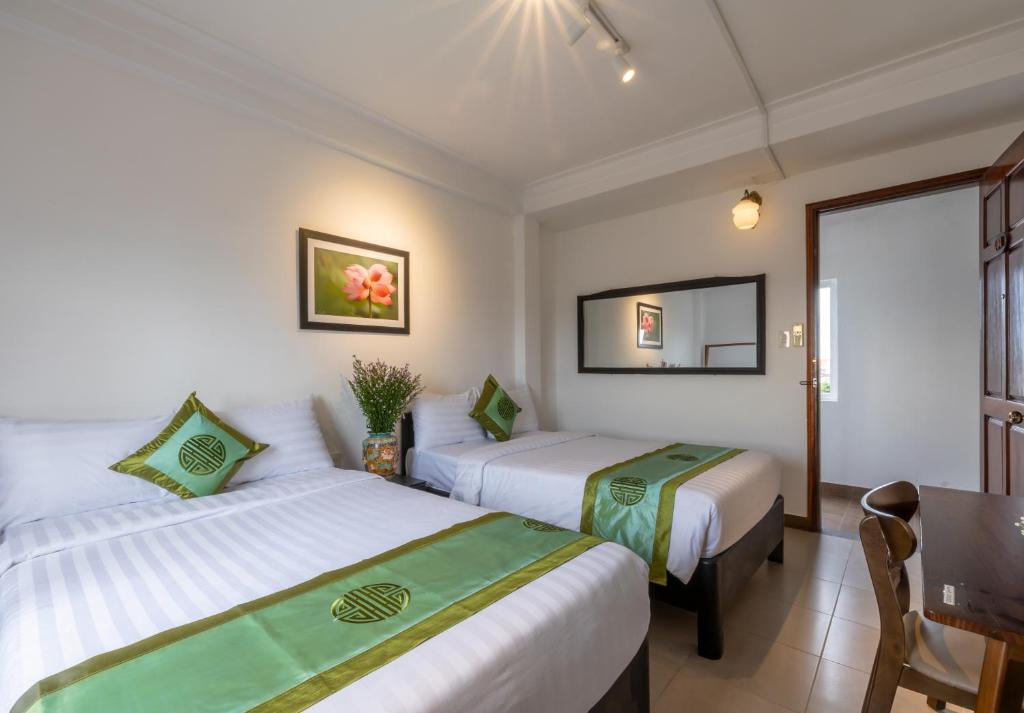 Giường trong phòng chung tại Charming Riverside Hotel