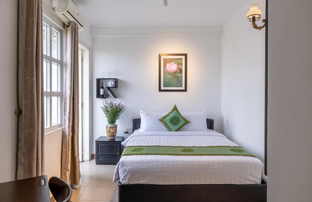 a bedroom with a large white bed in a room at Charming Riverside Hotel in Hue